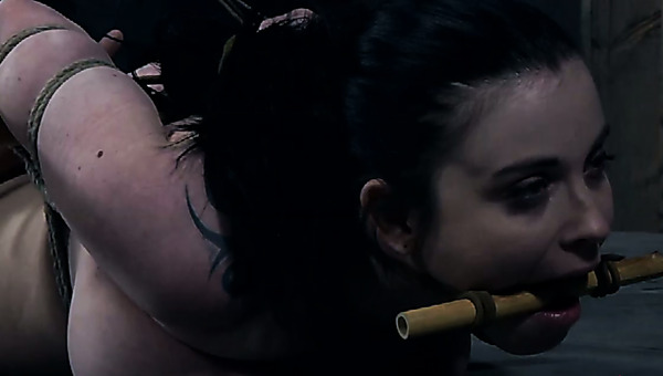 Brunette busty bombshell with tattoo is dominated by a cruel mistress