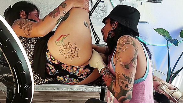 Brunette slut getting her pussy licked and rubbed during tattoo session
