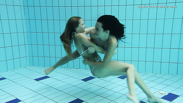 Two tempting mermaids caressing each other underwater