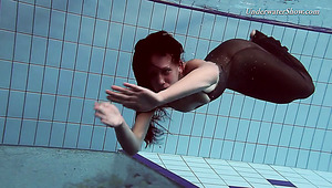 Skinny brunette hot babe in long black dress swimming underwater