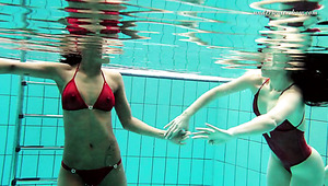 Two skinny and fresh white girls in red bikini undress in the pool