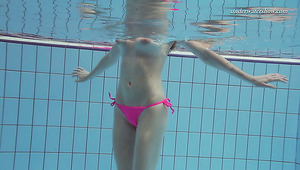 Hot redhead pale skin teen babe in pink bikini dives in the pool