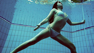 Brunette teen babe in sexy bikini stripteases underwater on cam